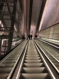Low angle view of escalator at illuminated railroad station