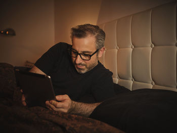 Midsection of man using mobile phone at home