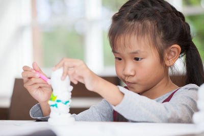 Close-up of girl coloring toy in classroom