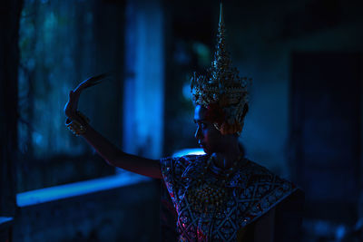 Rear view of woman standing against blue wall