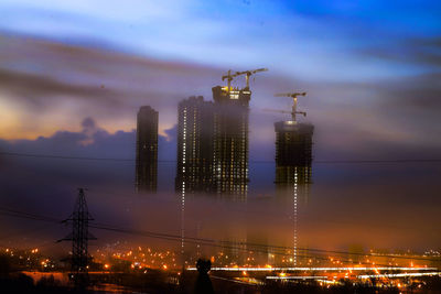 Low angle view of illuminated buildings against sky during sunset