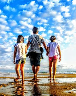 Rear view of people walking on beach