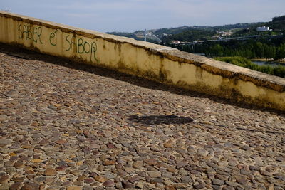 Text on retaining wall against sky