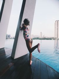 Rear view of woman in swimming pool against sky