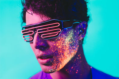 Close-up of man with multi colored face paint wearing eyewear