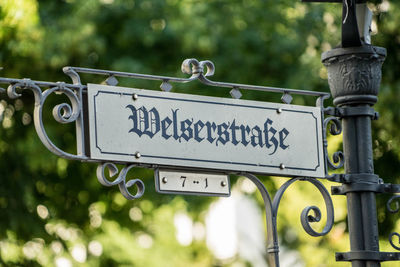 Low angle view of information sign against trees