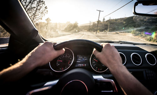 Cropped image of man driving car against sky