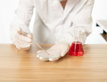 Midsection of person holding ice cream on table