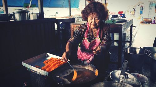 Full length of woman sitting on barbecue grill