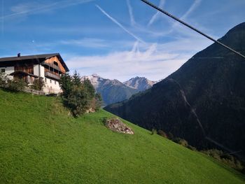 Scenic view of houses by mountains against sky