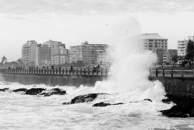 Scenic view of sea against buildings in city