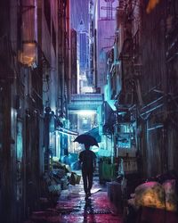 Rear view of silhouette man walking with umbrella in alley at night during rain