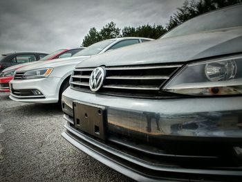 Cars on road against cloudy sky