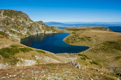 Scenic view of lake and mountains against blue sky