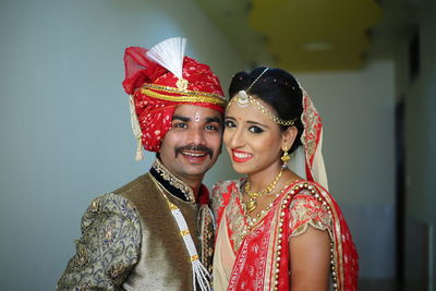 Smiling young couple standing against wall