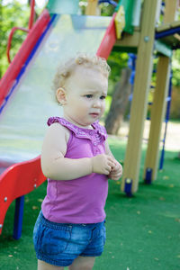 Cute girl looking away while standing at playground