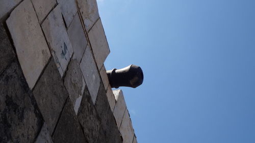 Low angle view of wall against clear blue sky