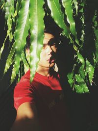 Portrait of serious man standing against tree