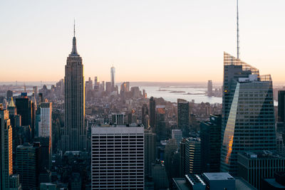 High angle view of cityscape and empire state building against clear sky during sunset