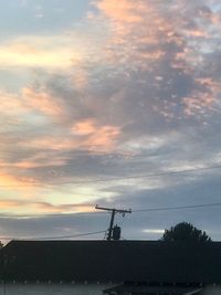 Low angle view of silhouette power lines against sky during sunset