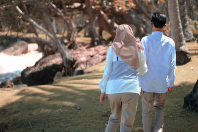 Rear view of couple kissing on field