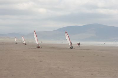 Scenic view of beach against cloudy sky