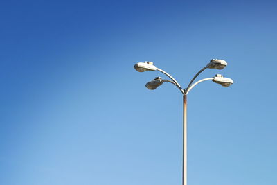 Low angle view of street light against clear blue sky