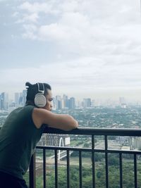 Side view of man photographing against sky