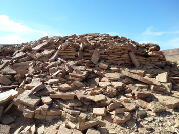 Stack of logs against sky