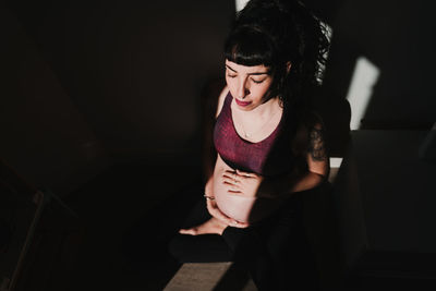 Pregnant woman exercising while sitting at home