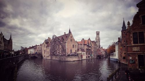 View of buildings in city against cloudy sky