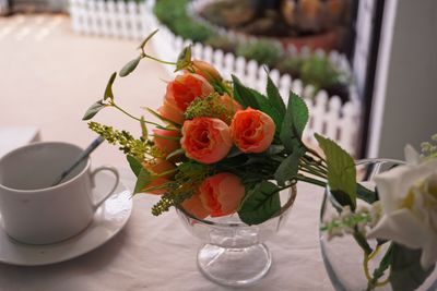 Close-up of cup and roses on table