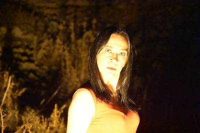 Portrait of beautiful woman standing at night