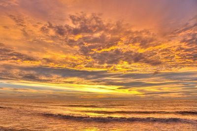 Sea under dramatic sky during sunrise