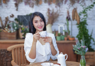 Portrait of a smiling young woman drinking coffee