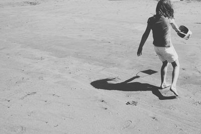 Rear view of girl playing at beach