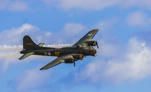 Low angle view of airplane flying against sky