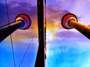 Low angle view of communications tower against cloudy sky