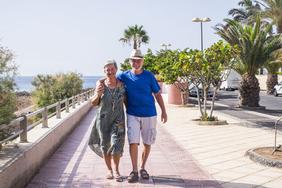 Full length of senior couple walking on promenade