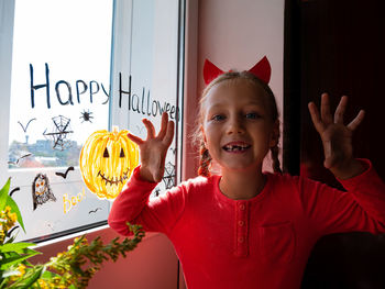 Child painting pumpkin window preparing celebrate halloween kid draws decorates room with paper bats