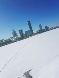 Buildings in city against clear blue sky