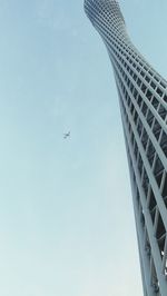 Low angle view of airplane flying against clear blue sky