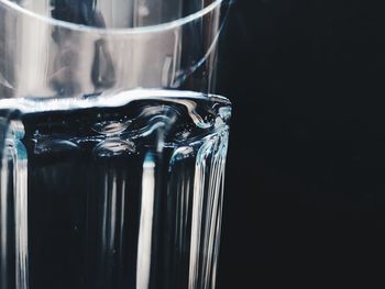 Close-up of glass of water against black background