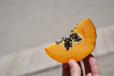 Cropped image of person holding orange