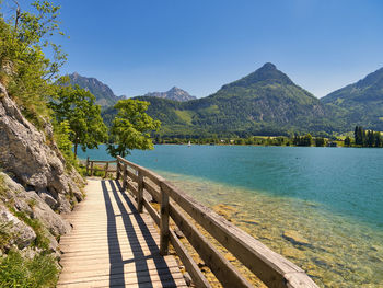 Scenic view of lake and mountains against blue sky