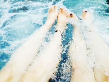 Low section of person swimming in pool