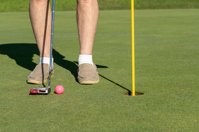 Low section of man standing on golf course