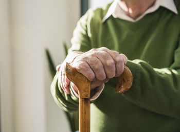 Close-up of senior man leaning on cane