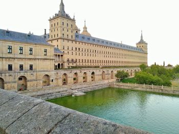 View of building by river against clear sky