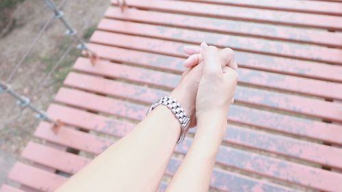 Cropped image of friends with holding hands over boardwalk